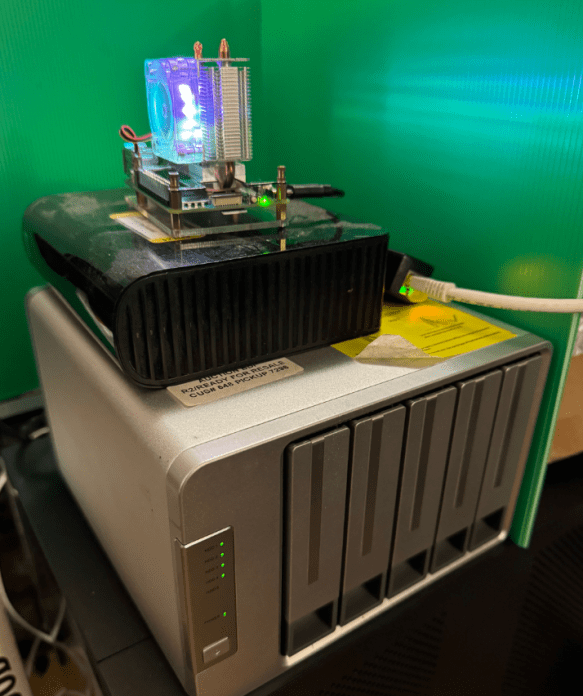 Raspberry Pi 5 with a lighted fan/heatsink cooler, sitting on drive arrays